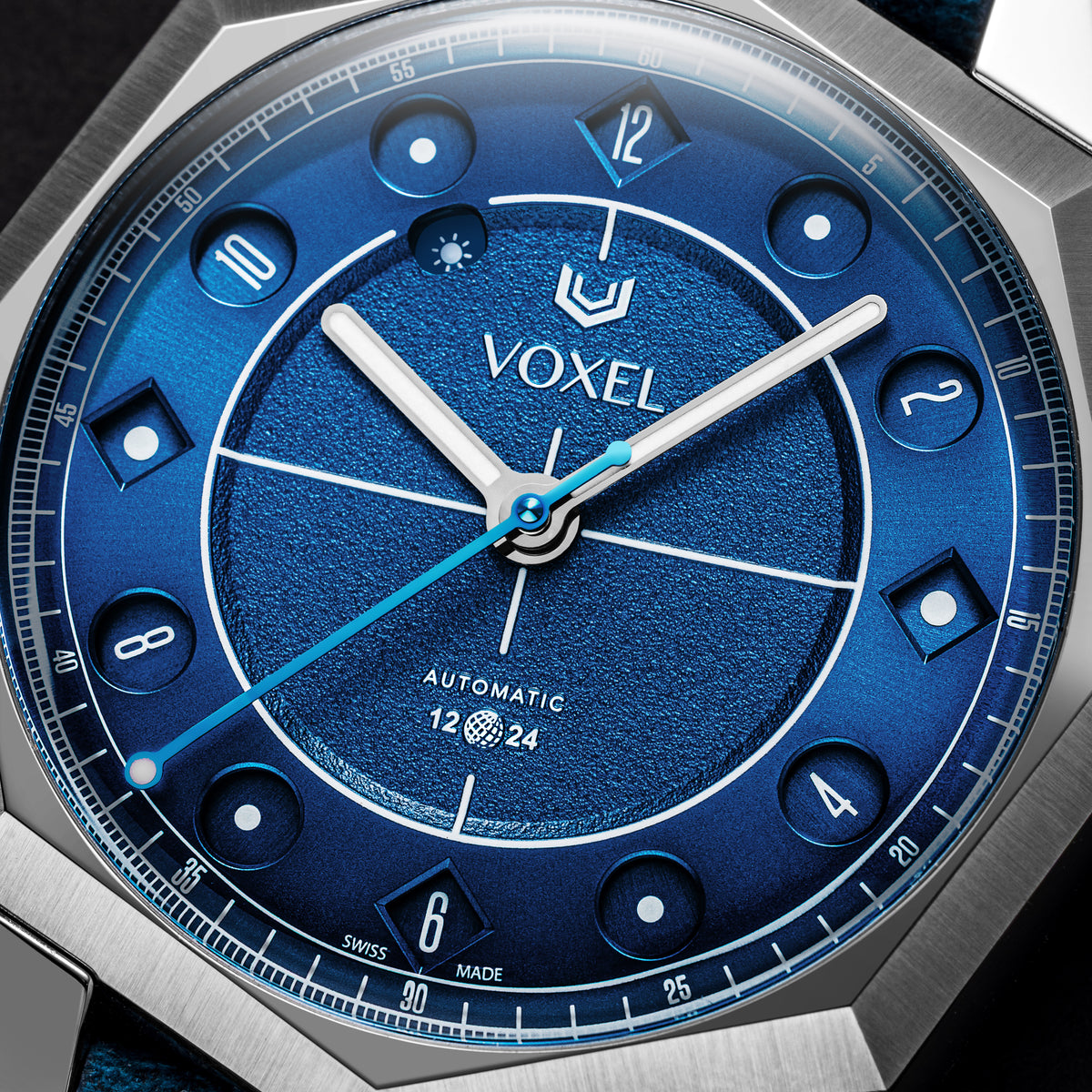 Close-up of the VOXEL Meridion Electric Blue Dial in 12-hour mode, showing the jumping-hours apertures, textured centre and light blue seconds hand