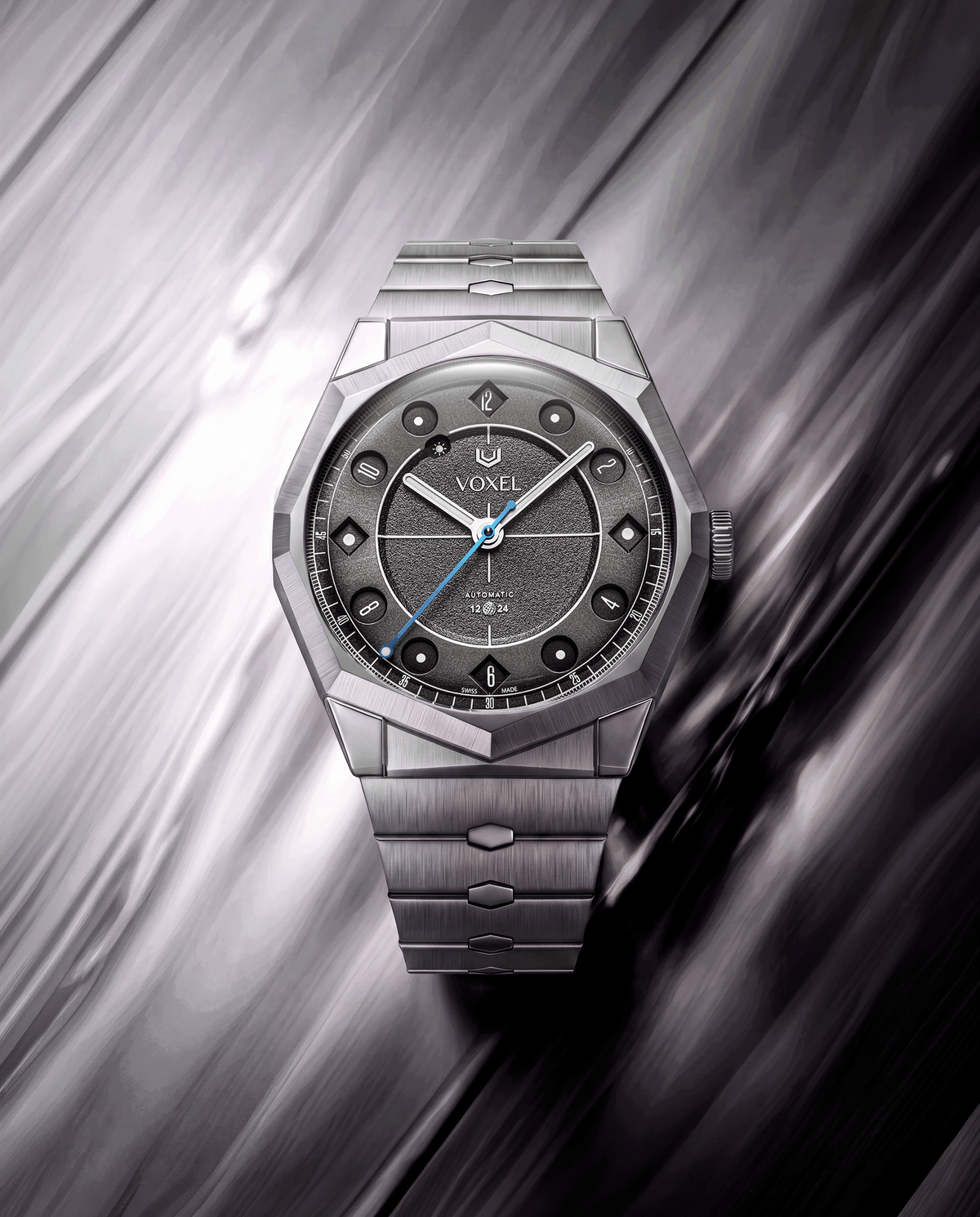 VOXEL Meridion Charcoal Black Dial on integrated 904L steel bracelet, angled view on a brushed metal background