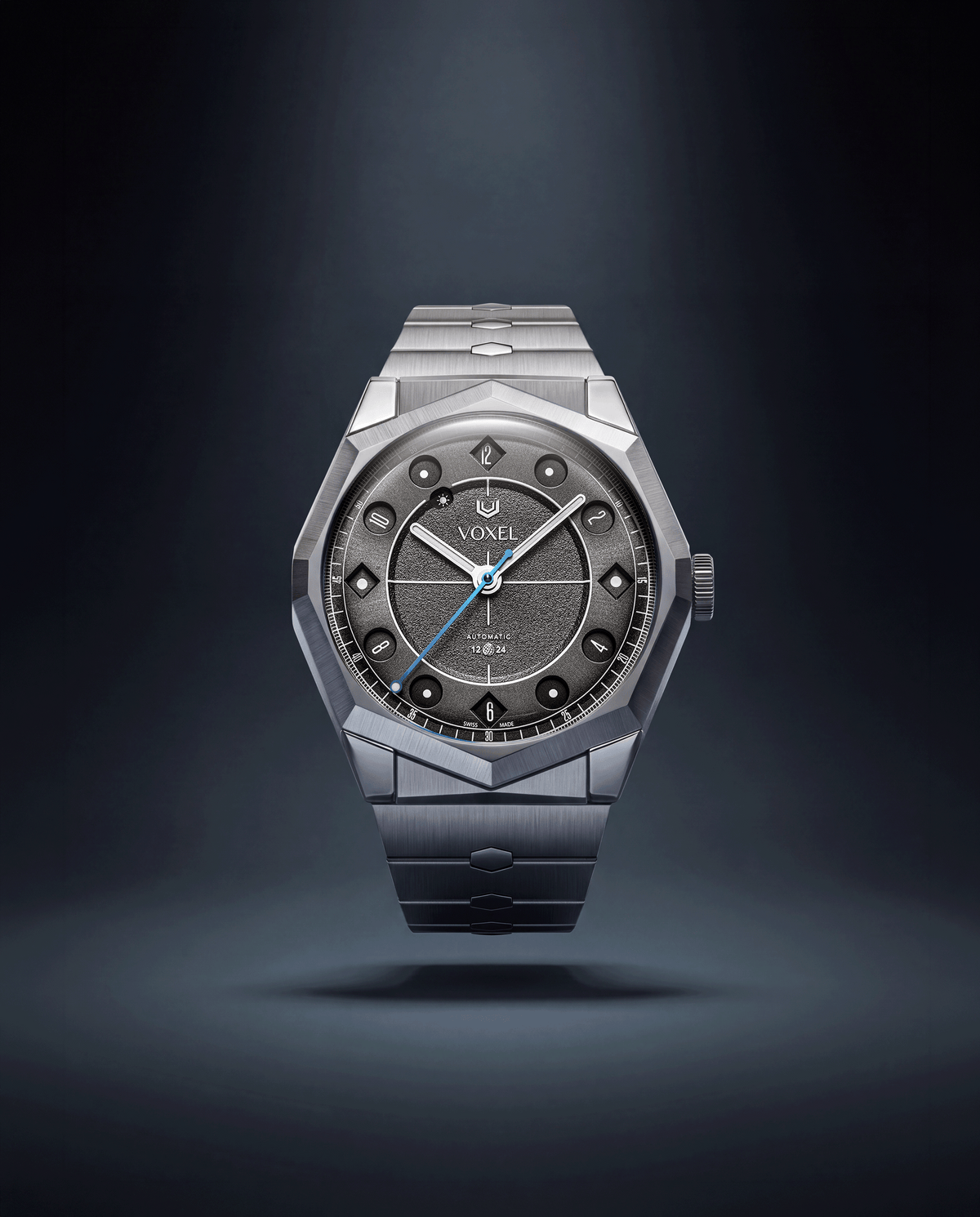VOXEL Meridion Charcoal Black Dial on integrated 904L steel bracelet, front view under soft spotlight